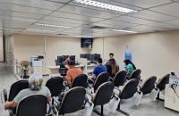 #ParaTodosVerem: Fotografia colorida em ambiente fechado, na foto está presente pessoas aguardando por atendimento. — Foto: ASCO