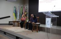 #ParaTodosVerem: Fotografia colorida em ambiente fechado, na foto está presente a mesa de conversa com dois servidores e uma mag