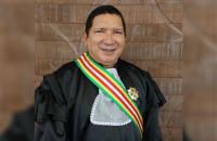 Descrição de imagem: Foto 1; Fotografia de perfil do desembargador Luís José de Jesus Ribeiro. Foto 2; Duas pessoas sentadas enq