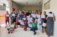 #ParaTodosVerem: Fotografia colorida em ambiente aberto, na foto está reunido os participantes do curso, todos estão em pé, segu
