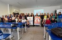#ParaTodosVerem: Foto colorida em ambiente fechado, reunindo várias pessoas entre homens e mulheres, todos estão em pé sorrindo 