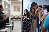 Fotografia em ambiente fechado que reúne homens e mulheres, lado a lado.