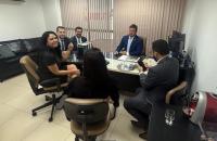 Foto em ambiente fechado mostrando a reunião das autoridades judiciais e representantes da empresa.