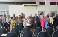 Foto de ambiente fechado que reúne a desembargadora e outros servidores da justiça do trabalho.