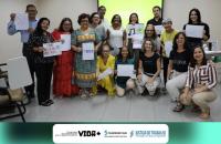 Fotografia em ambiente fechado que reúne dezenas de pessoas entre homens e mulheres. 