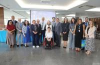 Fotografia em ambiente fechado que reúne dezenas de pessoas, entre homens e mulheres.