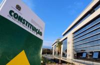 Foto colorida que mostra a Constituição da República Federativa do Brasildo em frente a fachada no CNJ. 