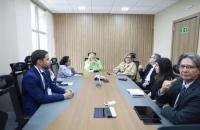 Fotografia em uma sala de reunião, que reúne homens e mulheres