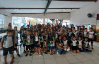 Foto em ambiente fechado com crianças, adolescentes e o músico Salomão Habib