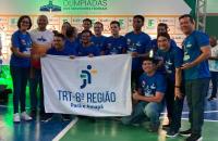 #ParaTodosVerem: Fotografia colorida reunindo homens e mulheres, todos estão em pé sorrindo para a foto e segurando a bandeira d