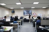 ParatodosVerem: Fotografia de um laboratório de informática, com diversas pessoas sentadas mexendo nos computadores. No centro,
