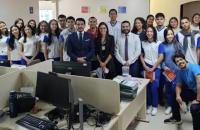 Foto colorida em ambiente fechado do juiz junto com os estudantes