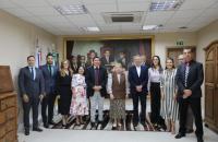 #ParaTodosVerem: Foto em espaço fechado, com diversas pessoas, entre homens e mulheres.