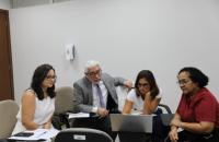 #ParaTodosVerem: Foto em espaço fechado com 3 mulheres e 1 homem, sentados, olhando para um notebook.