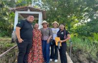 Fotografia em ambiente externo que reúne quatro pessoas lado a lado, sendo quatro mulheres e um homem