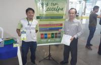 duas pessoas na frente do banner do projeto ecocelpa