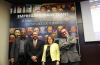 foto colorida com os palestrantes do último dia do evento tendo ao fundo o banner do evento com a frase "empregabilidade trans"