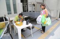 Na foto, servidora aguarda a pesagem do material reciclável.