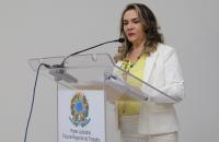 presidente no fundo branco em pé na frente do púlpito falando.