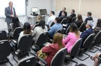 mini auditório lotado de servidores com o desembargador Walter Paro ao fundo.