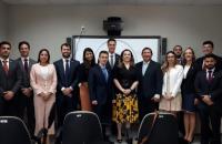os dozes juizes com a presidente  o diretor da escola judicial em pé no fundo branco.