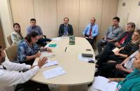 todos sentados em uma mesa discutindo assuntos da reunião.