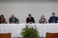 Convidados da mesa redonda sentados na mesa do auditório da EJUD