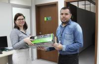 Foto mostra servidora entregando item da logística reversa para chefe da seção socioambiental