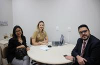 Foto: mesa de conciliação composta pelas duas partes e a juíza.