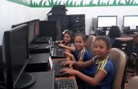 Na foto: Crianças no laboratórios multimídia da escola, usando os computadores.