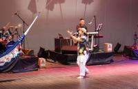 Na foto: o humorista Epaminondas Gustavo, vestido com uma camiseta e uma calça branca, no palco do teatro Margarida Schiwazzapa.