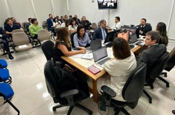 Foto de ambiente fechado que reúne homens e mulheres em audiência