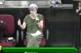 Foto colorida em ambiente fechado com a presente vestindo roupas sociais