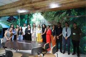 #ParaTodosVerem: Fotografia em ambiente fechado, na imagem, estão 14 pessoas de pé e sorrindo para a foto 