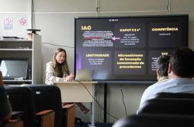 #ParaTodosVerem: Fotografia colorida em ambiente fechado. Na foto aparece Rosane Dalazen, sentada ministrando o curso. 