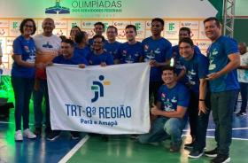 #ParaTodosVerem: Fotografia colorida reunindo homens e mulheres, todos estão em pé sorrindo para a foto e segurando a bandeira d