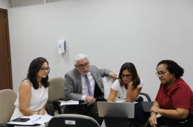 #ParaTodosVerem: Foto em espaço fechado com 3 mulheres e 1 homem, sentados, olhando para um notebook. 