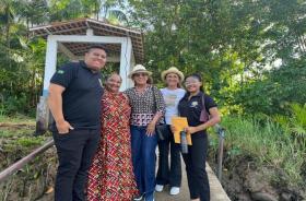 Fotografia em ambiente externo que reúne quatro pessoas lado a lado, sendo quatro mulheres e um homem